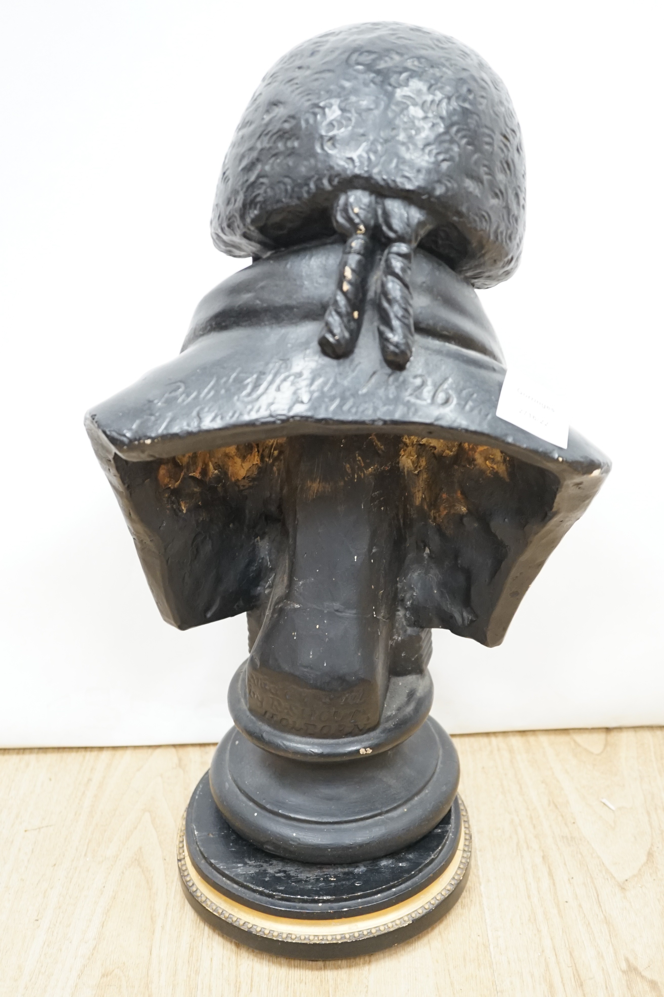 A black painted plaster bust of a judge, inscribed 1826, 49cms high.